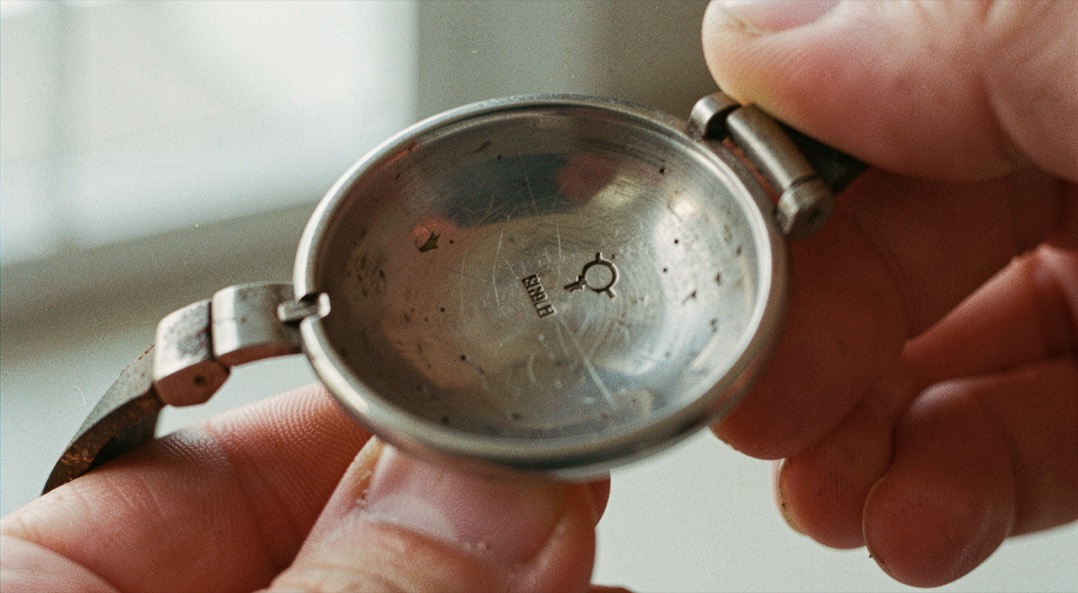 Intérieur d'un bracelet ouvert montrant un poinçon frappé peu visible sous la lumière